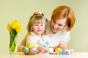 mother and daughter kid painting easter eggs